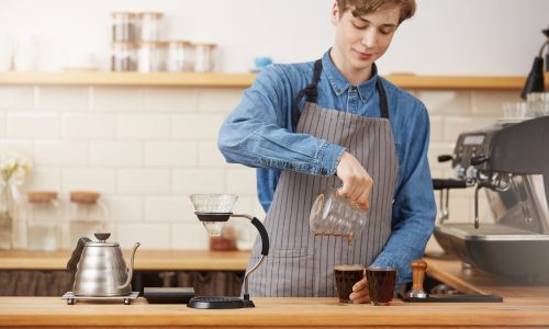 Bartender hands pouring alternative coffee into two glass cups Certificate III in Hospitality