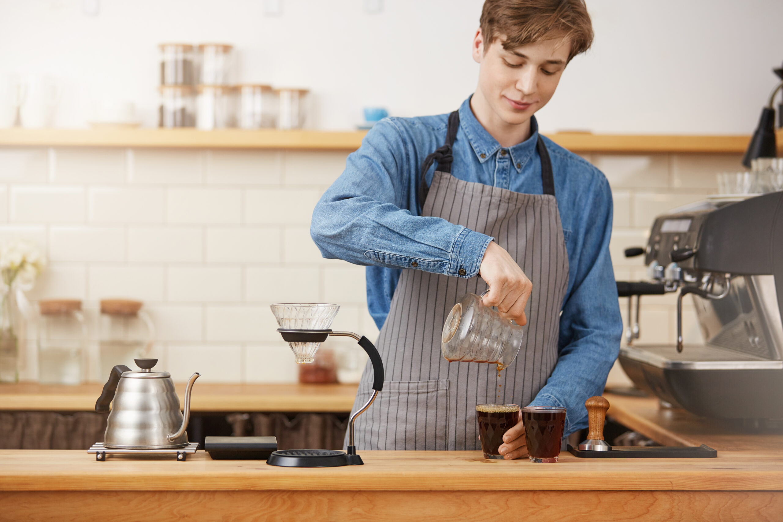 Bartender hands pouring alternative coffee into two glass cups Bartender hands pouring alternative coffee into two glass cups